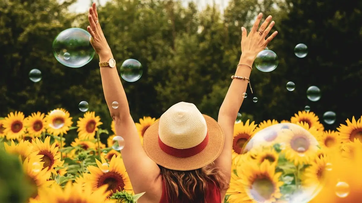 Mujer disfrutando de un campo de girasoles en verano con burbujas de jab&oacute;n, naturaleza en Le&oacute;n